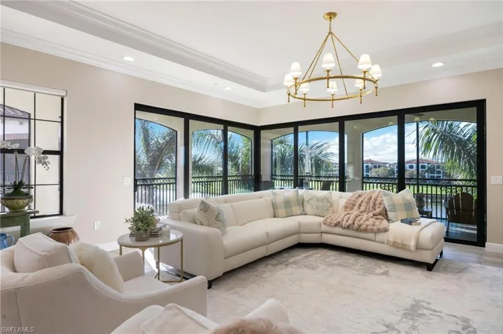 Living area with plenty of natural light, hanging lights, and a tray ceiling