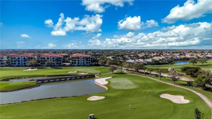 Aerial perspective of suburban area featuring a golf club and a nearby body of water