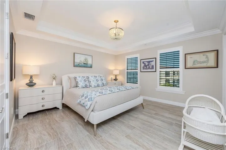 Bedroom with a chandelier, crown molding, and a tray ceiling