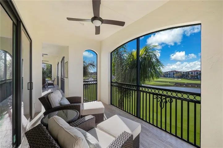 Sunroom / solarium featuring a balcony, ceiling fan, and a water view