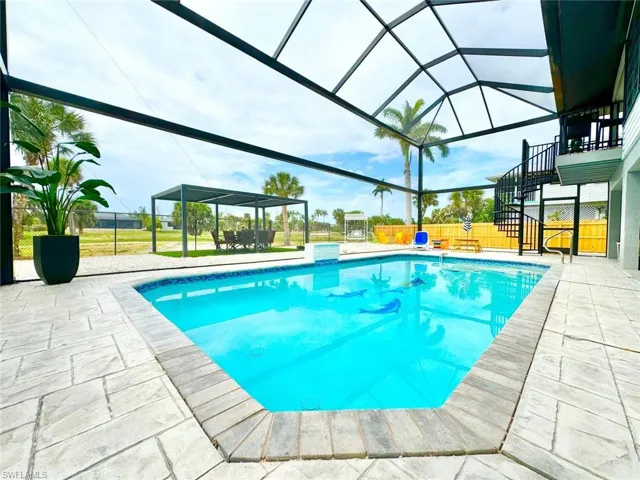 Outdoor pool featuring a patio area, a lanai, a sunroom, and a fenced backyard