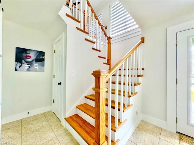 Staircase featuring tile patterned flooring and baseboards