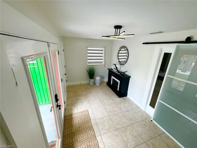 Foyer featuring light tile patterned flooring and baseboards
