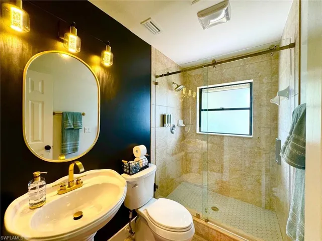 Bathroom with a shower stall and toilet