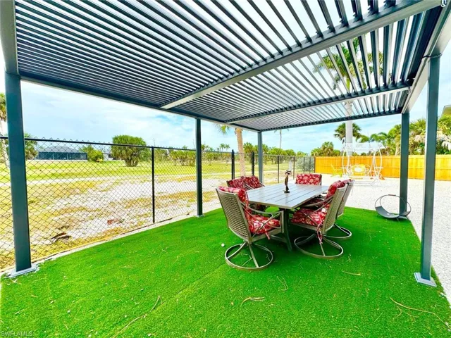 Fenced backyard featuring outdoor dining area and a pergola