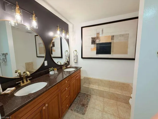 Bathroom featuring double vanity and light tile patterned floors