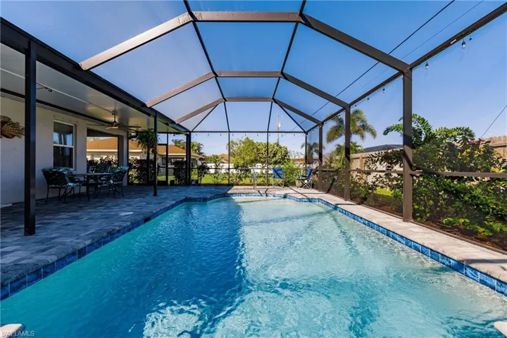 View of pool with a lanai, ceiling fan, and a patio area
