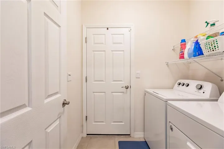 Washroom featuring separate washer and dryer and light tile patterned floors