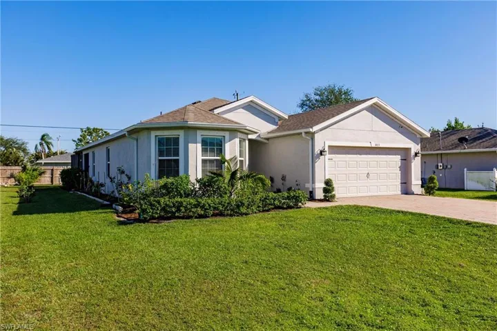 Ranch-style home with a front yard and a garage