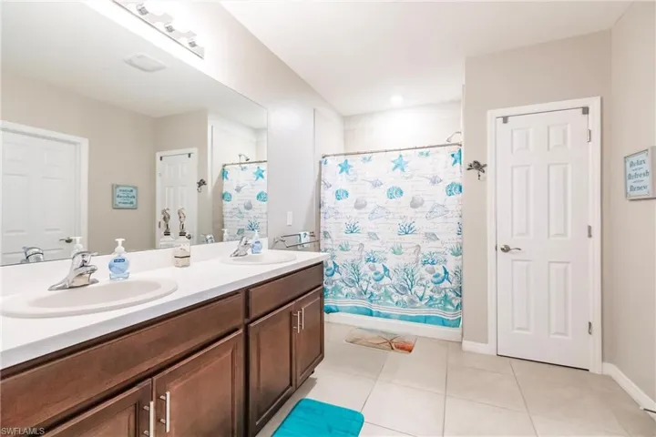 Bathroom featuring tile patterned floors, vanity, and shower / tub combo