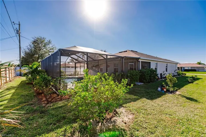 Back of property featuring a lanai and a yard