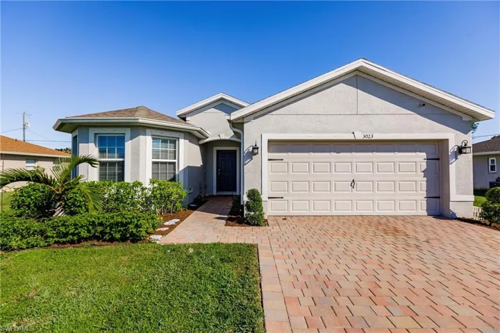 View of front of property with a garage and a front lawn