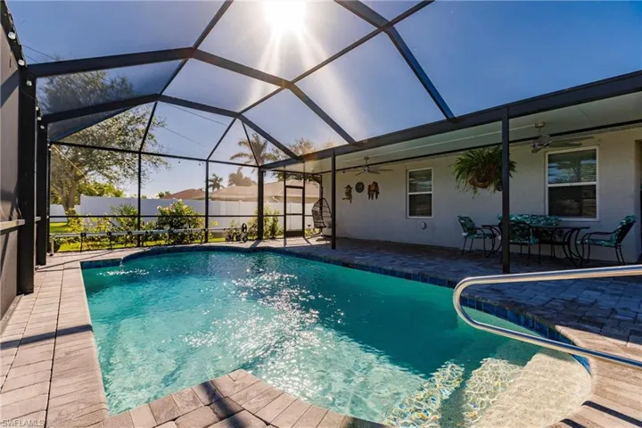 View of pool with ceiling fan, a patio, and glass enclosure