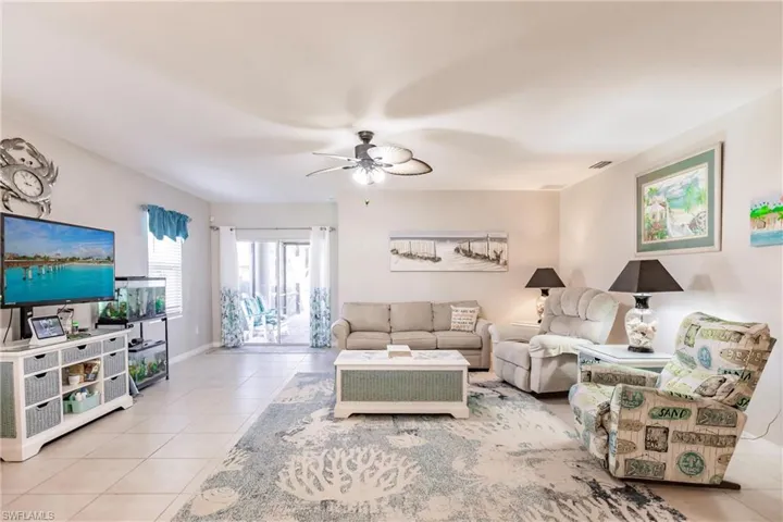 Living room with ceiling fan and light tile patterned floors