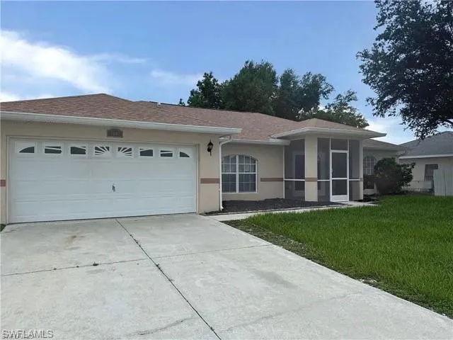 Ranch-style house featuring concrete driveway, a garage, a front yard, and stucco siding