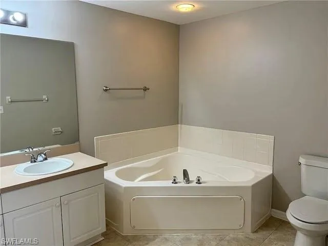 Bathroom featuring a garden tub, vanity, and tile patterned flooring