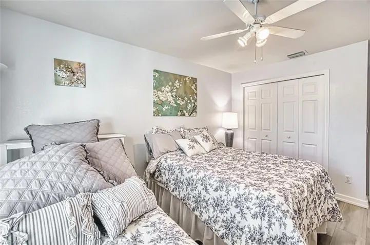 Bedroom with wood finished floors, a closet, and ceiling fan
