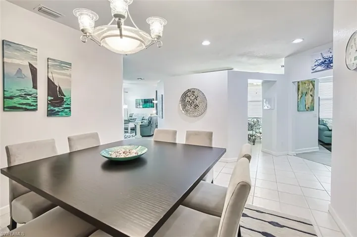 Dining area featuring a chandelier, light tile patterned floors, and recessed lighting