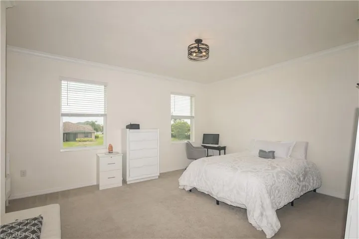 Carpeted bedroom with crown molding