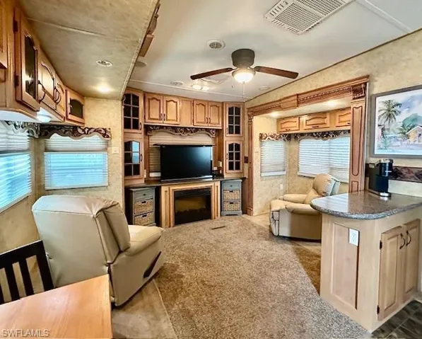 Living room featuring carpet and ceiling fan