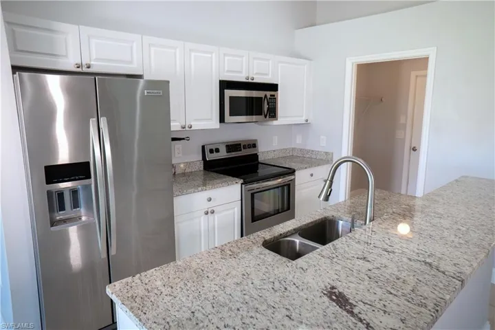 Kitchen with a view through the dining area and out the large window and sliding door.