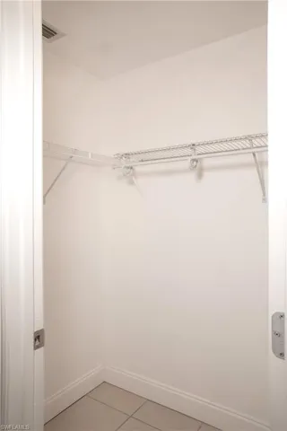 Hallway to the master bathroom featuring two walk in closets.