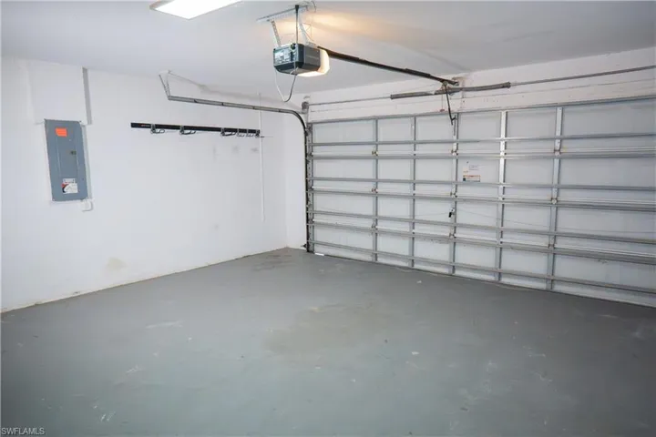 Garage featuring electric water heater and an automatic garage door opener