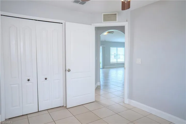 Bedroom #2 with a ceiling fan and window view of the front yard.