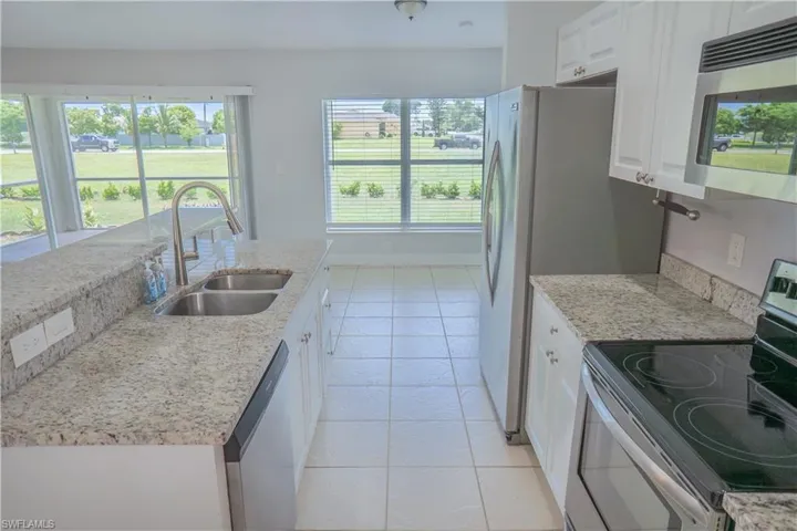 Kitchen with a view across the living room with natural light entering through the sliding door.