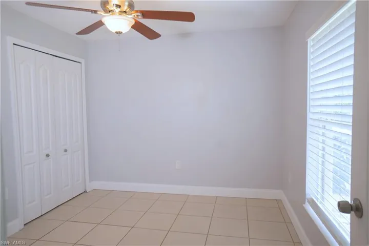 Den room nestled in the front of the home with ceiling fan and window
