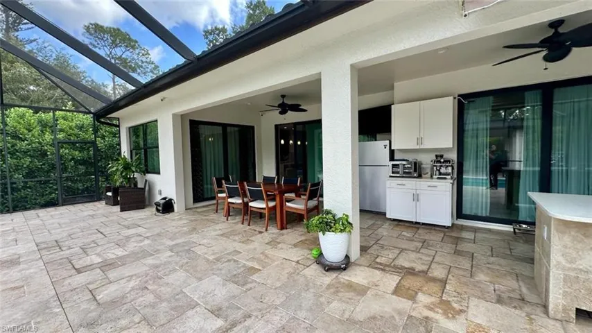 View of patio with a ceiling fan, outdoor dining area, a sunroom, and a lanai