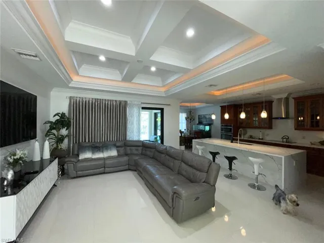 Living area with crown molding, coffered ceiling, beamed ceiling, and recessed lighting