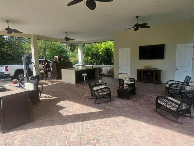 View of patio / terrace with a ceiling fan and a bar