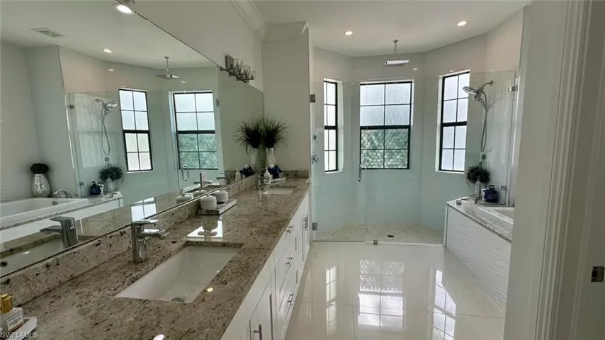 Bathroom featuring double vanity, a marble finish shower, light tile patterned flooring, a bath, and recessed lighting