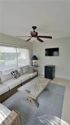 fLORIDA room with a textured ceiling, light tile patterned floors, and ceiling fan