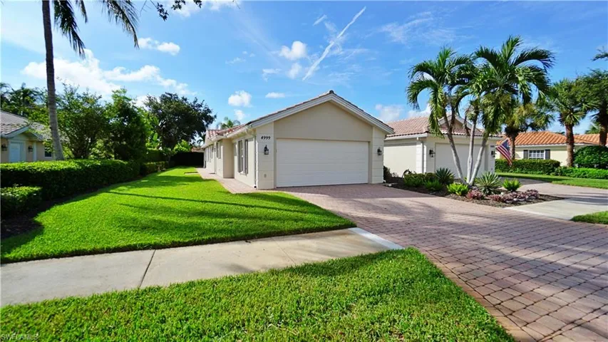 View of front of property with a garage and a front lawn