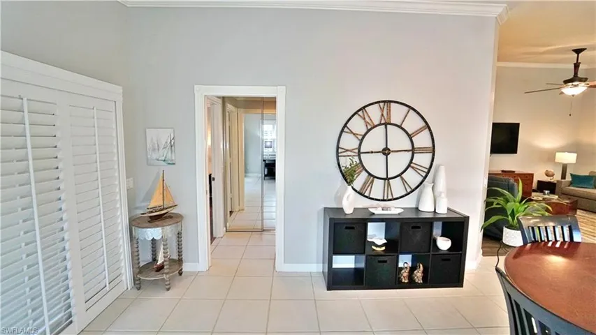 Hallway with tile patterned floors and ornamental molding