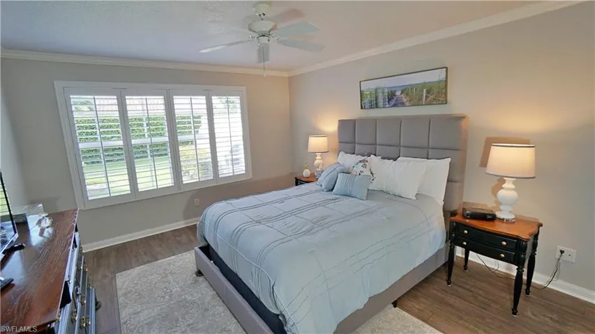 Bedroom with crown molding, ceiling fan, and hardwood / wood-style flooring