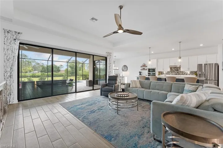 Living room with a ceiling fan, visible vents, recessed lighting, and light wood-style flooring