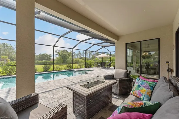 Pool featuring a patio area, a lanai, and an outdoor living space with a fire pit
