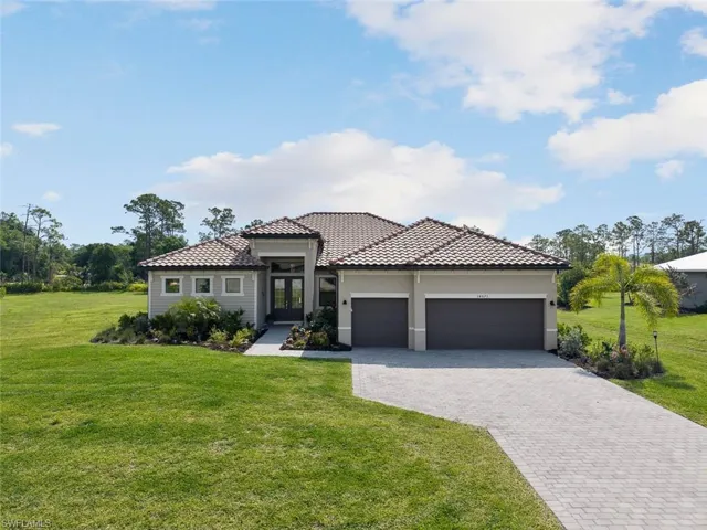 Mediterranean / spanish home featuring a tiled roof, an attached garage, french doors, decorative driveway, and a front yard