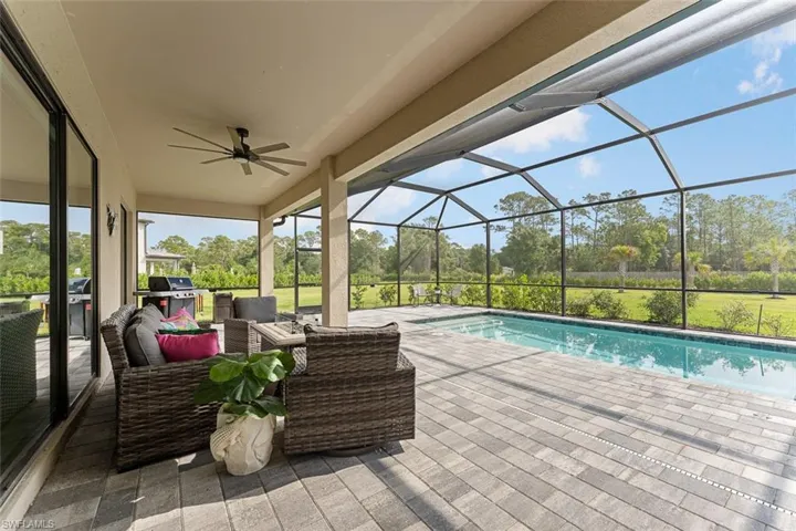 Pool with a patio area, outdoor lounge area, glass enclosure, and a ceiling fan