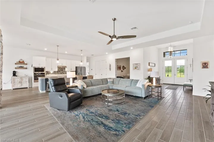 Living room featuring recessed lighting, visible vents, and a raised ceiling