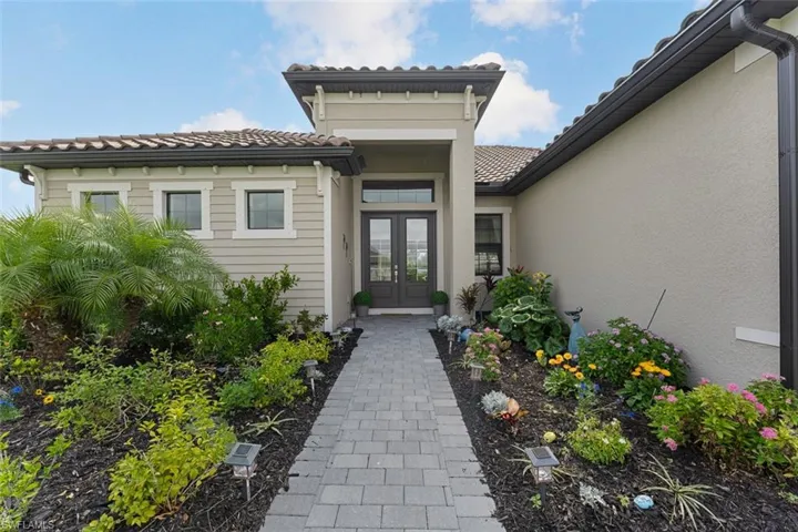 Entrance to property with stucco siding, a tiled roof, and french doors
