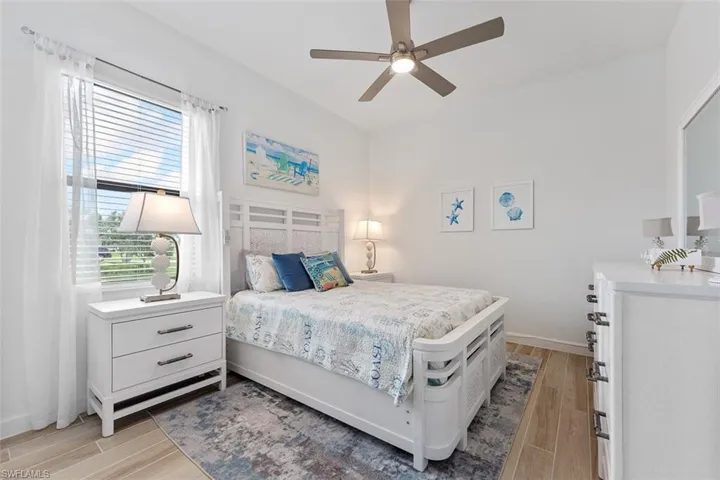 Bedroom with light wood-type flooring, baseboards, and ceiling fan