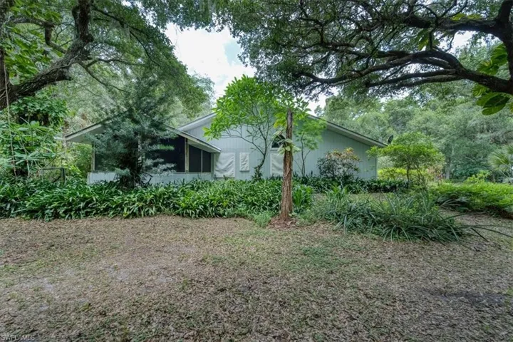 East side of home with mature landscaping and private porch off master suite