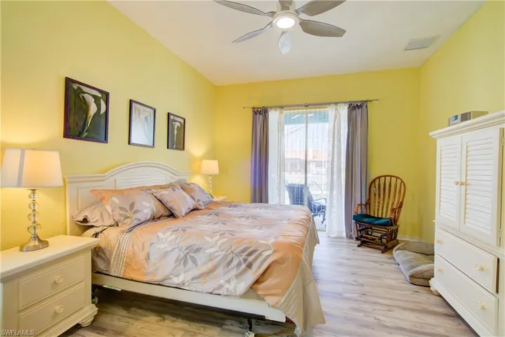 Bedroom with visible vents, access to exterior, ceiling fan, and light wood-type flooring