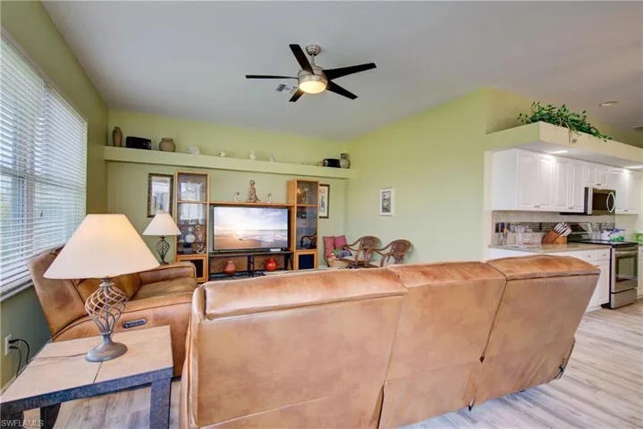 Living area with light wood-style floors and a ceiling fan