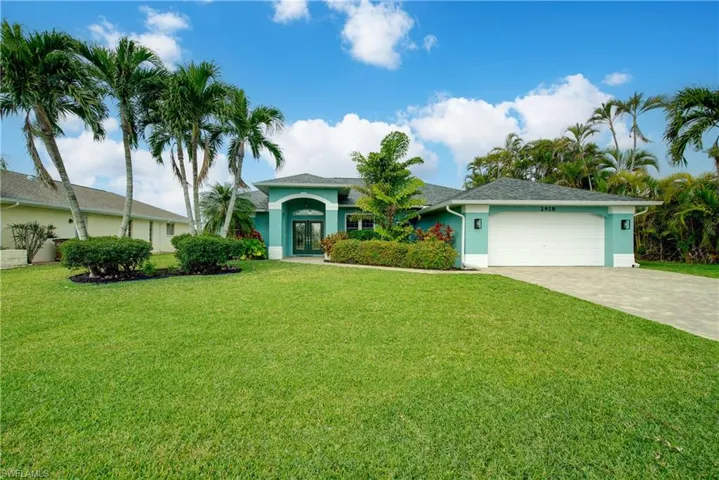View of front of property with french doors, decorative driveway, stucco siding, and an attached garage