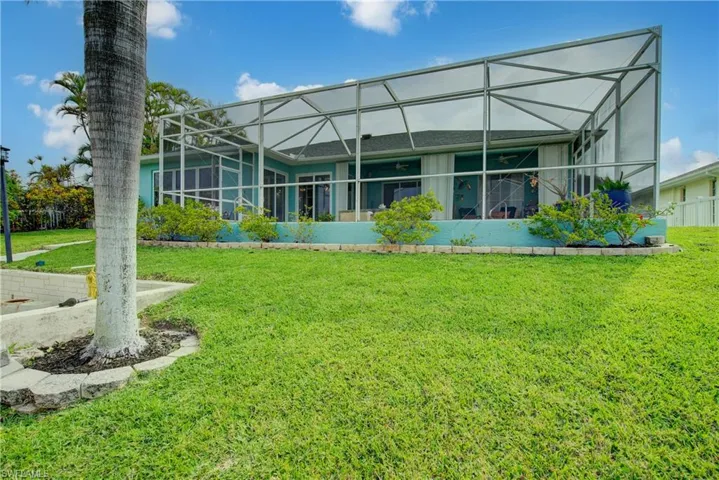 Back of property with a lanai, stucco siding, and a yard